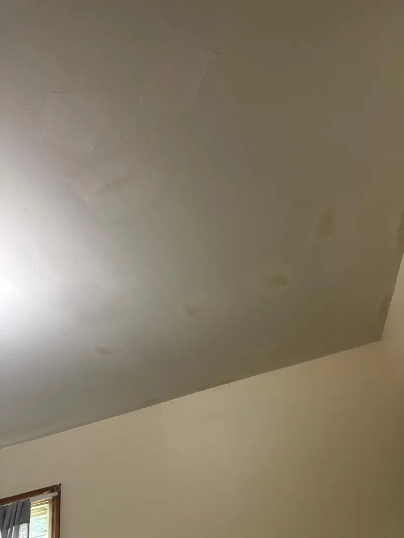 Ceiling with water stains and patches before drywall repair in Greenville, SC