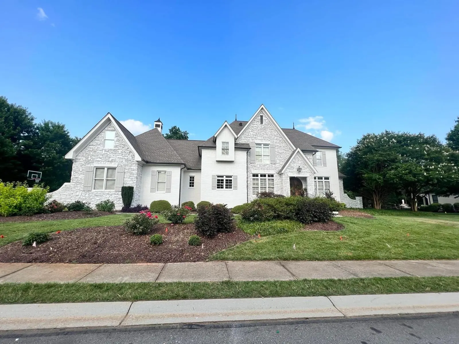 White-painted stone and brick home in Greenville, SC repainted by Straight Line Painting