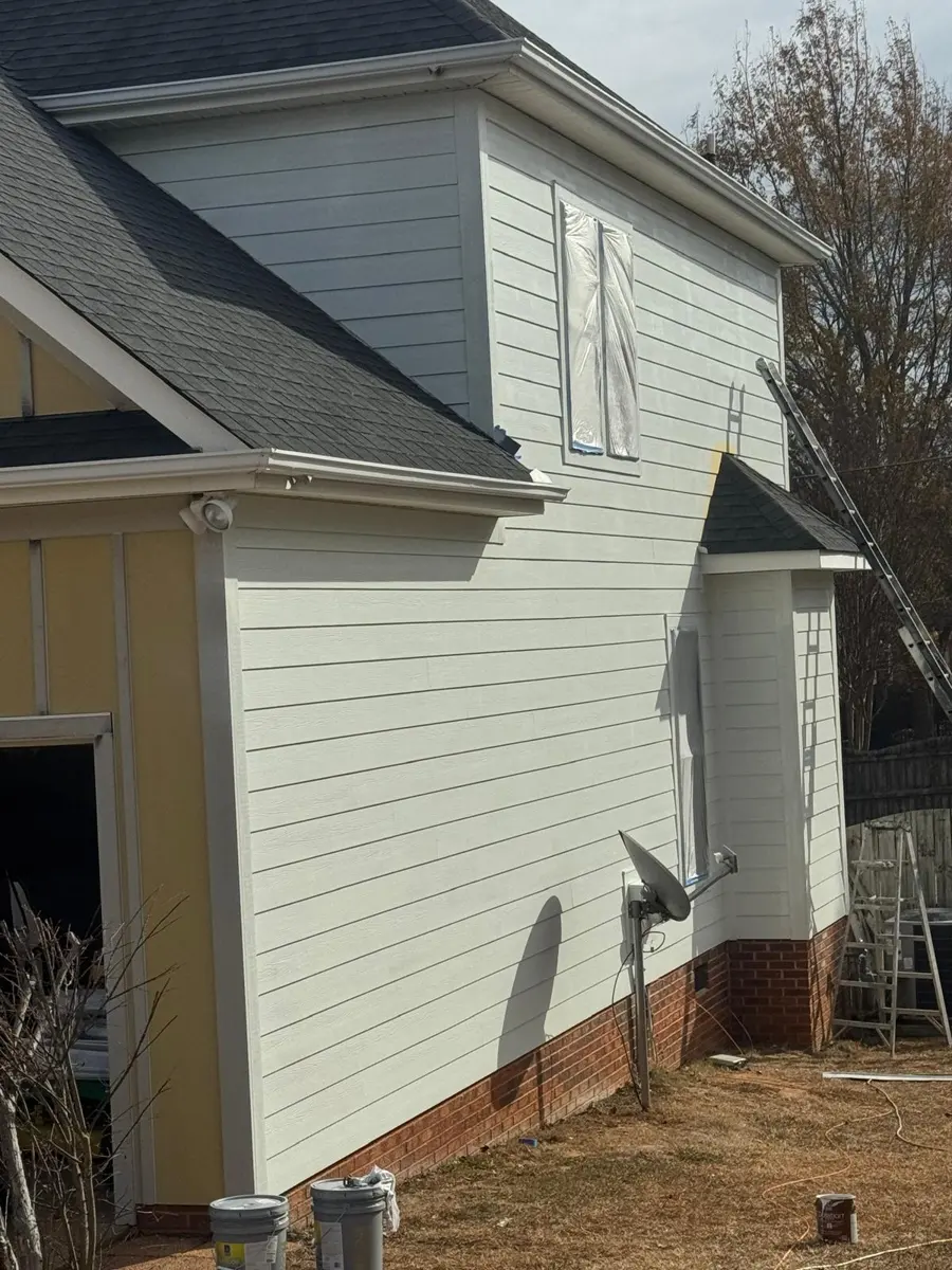 Exterior siding repainted white with windows masked, Greenville, SC