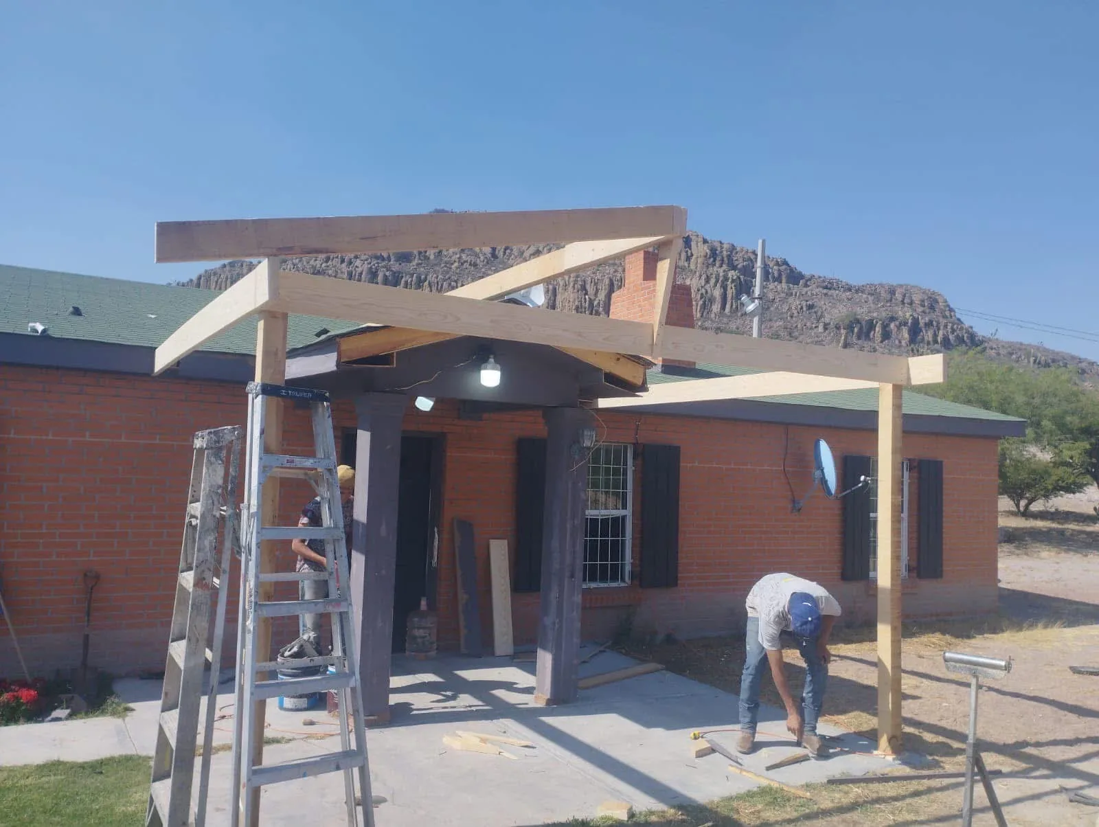 Wood framing and workers building an exterior porch structure
